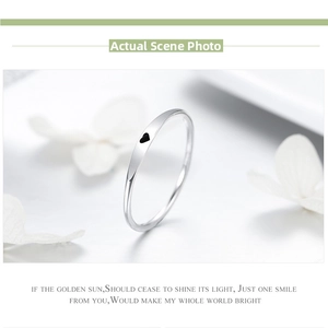 Close-up of minimalist S925 sterling silver ring with black enamel heart detail