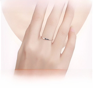 Close-up of a minimalist 925 silver ring featuring a small black enamel heart on a finger