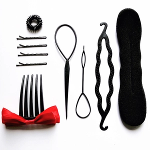 Macro shot of 11-piece black hair styling tool set with comb and clips on white background