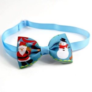 Detail of light blue Christmas pet bowtie with Santa Claus print and golden bell