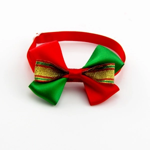Detail of red and green Christmas pet bowtie with golden bell and adjustable white strap