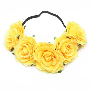 Detailed view of yellow artificial rose headband with five fabric flowers and black elastic band