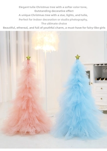 Close-up of pink and blue tulle Christmas trees with glitter star toppers on tabletop