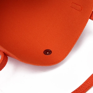 Close-up of orange litchi texture PU leather bag with magnetic snap and fabric lining