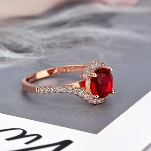 Rose gold engagement ring with round red zircon center stone and halo setting