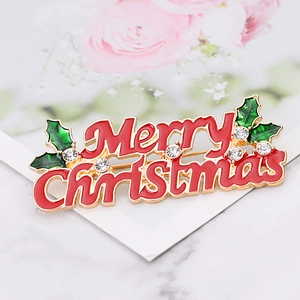 Detail of enamel Merry Christmas brooch with green holly leaves and sparkling crystals