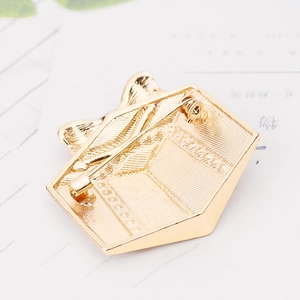 Macro detail of Christmas brooch gold metal back with pin fastener and textured finish
