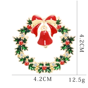 Detail of Christmas wreath brooch with red berries, green holly leaves and crystal bell