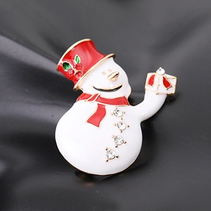 Macro shot of snowman brooch with white enamel, red hat and sparkling crystal rhinestones