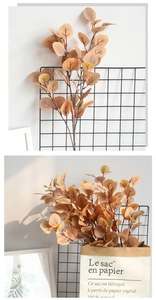 Detail of faux eucalyptus branches in autumn orange with realistic leaf veins and texture