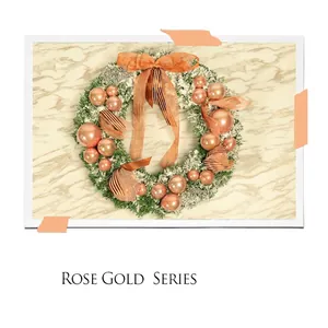 Rose gold Christmas wreath with snowy pine needles and Merry Christmas plaque