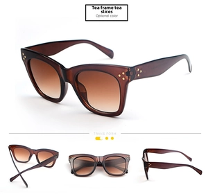 Detail view of oversized tea-colored sunglasses with triple gold rivets and gradient lenses