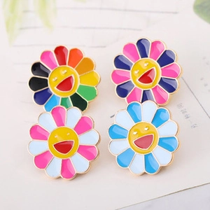 Detail shot of four colorful smiling sun flower pins featuring artistic enamel craftsmanship