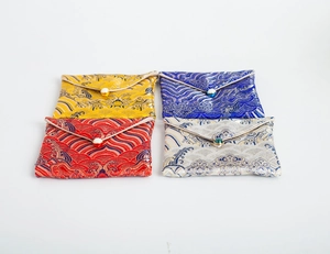 Detailed view of four colorful brocade jewelry pouches with traditional wave patterns