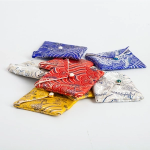 Traditional brocade jewelry pouches with wave patterns and bead closures in multiple colors