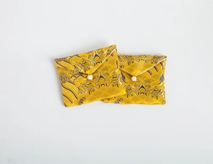Close-up of golden brocade jewelry pouches with traditional Chinese patterns and bead closure