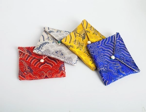 Detailed macro of silk brocade jewelry pouches with traditional wave patterns and beads