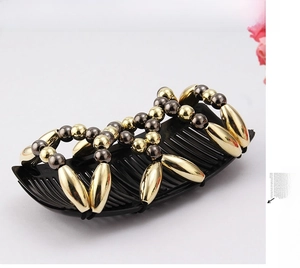 Detail of beaded magic hair comb showing gold and grey beads on flexible elastic bands