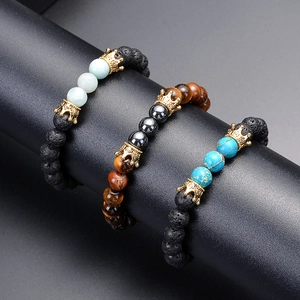 Lava stone and tiger eye beaded bracelets with gold zircon crown charms on black stand