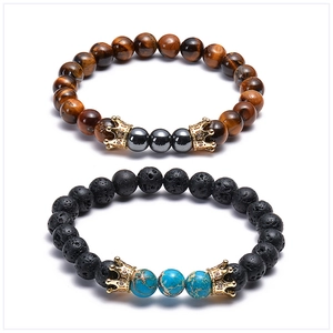 Close-up of lava stone and tiger eye bead bracelets with zircon-encrusted gold crowns