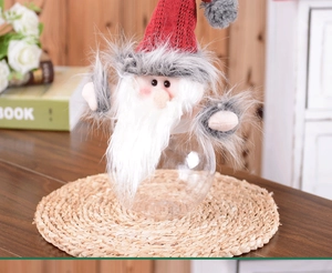 Close-up of Santa Claus candy jar with red knit hat and transparent globe container