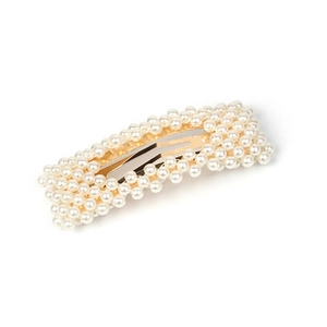 Close-up of a rectangular hair clip featuring multiple rows of white pearls on gold metal