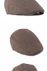 Detail view of the dense herringbone weave pattern on this classic men's brown ivy flat cap