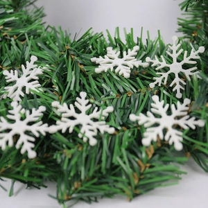 Close-up of 5cm white laser-cut felt snowflakes on a green artificial pine garland