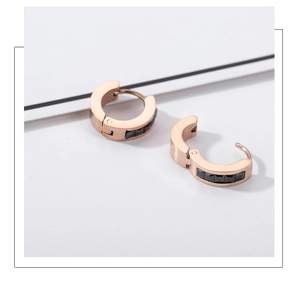Close-up of rose gold hoop earrings featuring black rectangular cubic zirconia stones