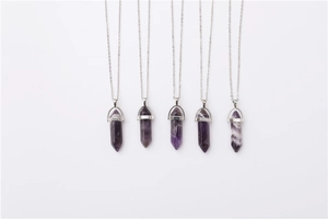 Detail view of five hexagonal purple amethyst crystal point pendants on silver necklaces