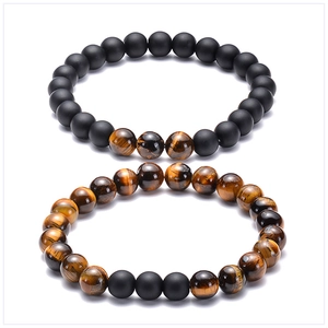Detail view of 8mm tiger eye and matte black stone beaded bracelets with natural texture