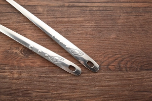 Detail of stainless steel spoon handles with leaf pattern and hanging holes