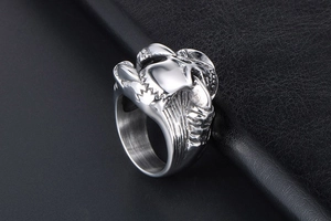 Detailed view of silver skull punk ring on black leather background with matte finish