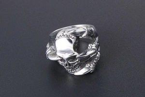 Detailed close-up of a silver skull ring featuring gothic eagle claw carving details