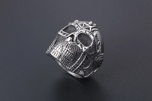 Detail shot of gothic skull ring in silver titanium steel with intricate embossed patterns