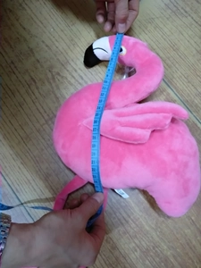 Detailed view of pink flamingo plush toy being measured at 25cm with a tape measure