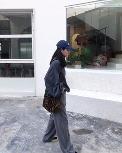 Lifestyle shot of chic leopard print canvas tote bag paired with navy blue sweatshirt