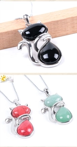 Detailed macro view of cat-shaped stone pendants in black onyx and red turquoise styles