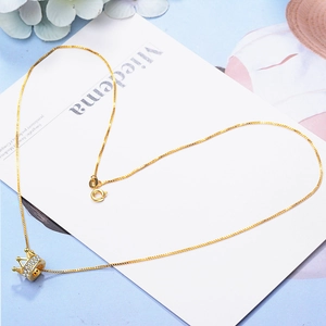 Elegant gold crown pendant necklace with white zircons on a delicate box chain
