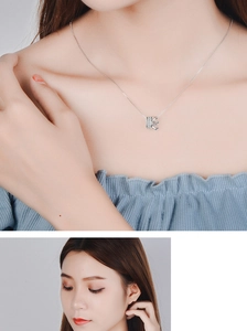 Detail of silver crown pendant necklace with zircons on model neck and profile view