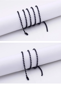 Detail of a black beaded stainless steel necklace showing the smooth beads and clasp