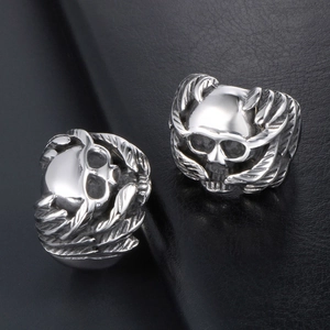 Vintage silver skull rings with wing motifs in gothic style on black leather background