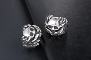 Detailed macro view of vintage gothic skull ring with intricate wing textures on black leather