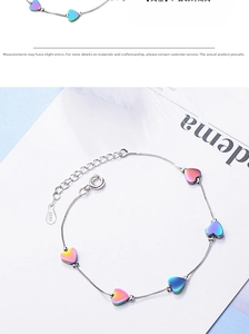 Detail of S925 sterling silver bracelet featuring five rainbow metallic heart charms