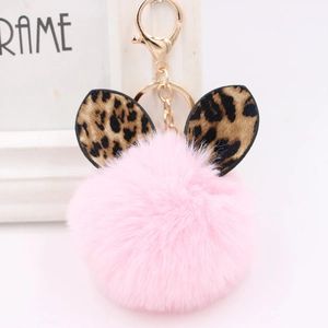 Macro detail of pink faux fur keychain with leopard print ears and gold metal clip