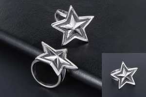 Close-up of two punk style silver titanium star rings on a dark leather surface