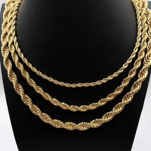 Close-up of three layered gold twisted rope necklaces in different thicknesses and lengths