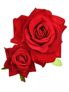 Macro detail of red velvet fabric roses with realistic petals and green leaves