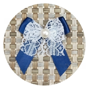Detail of navy blue ribbon bow with white lace and pearl bead for DIY crafts