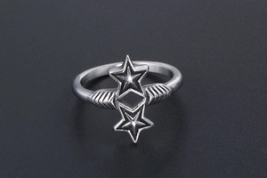 Detailed close-up of a silver-tone ring featuring two hollow stars and wing elements